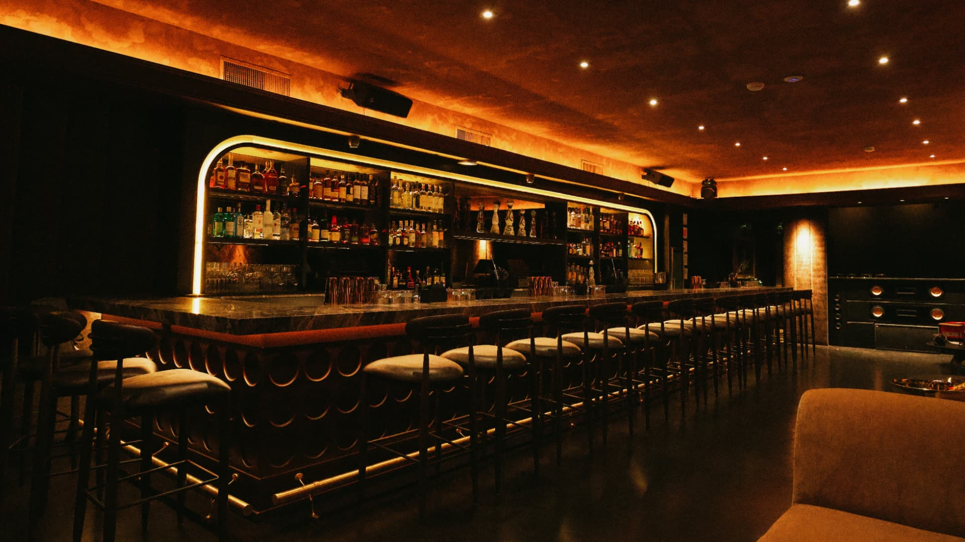 Long marble bar glowing under warm amber light